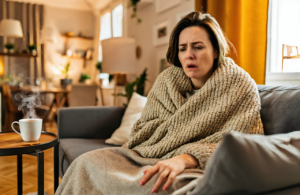 Woman resting at home with a lingering cough and a mug of hot tea near Ocean Springs