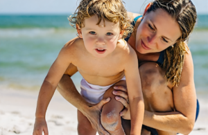 A mother and young child on a sunny Mississippi Gulf Coast beach
