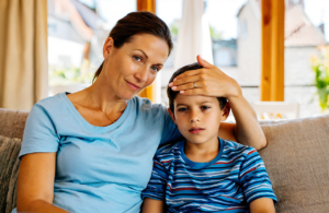 Gautier mother checking her young son for a fever at home before an urgent care visit