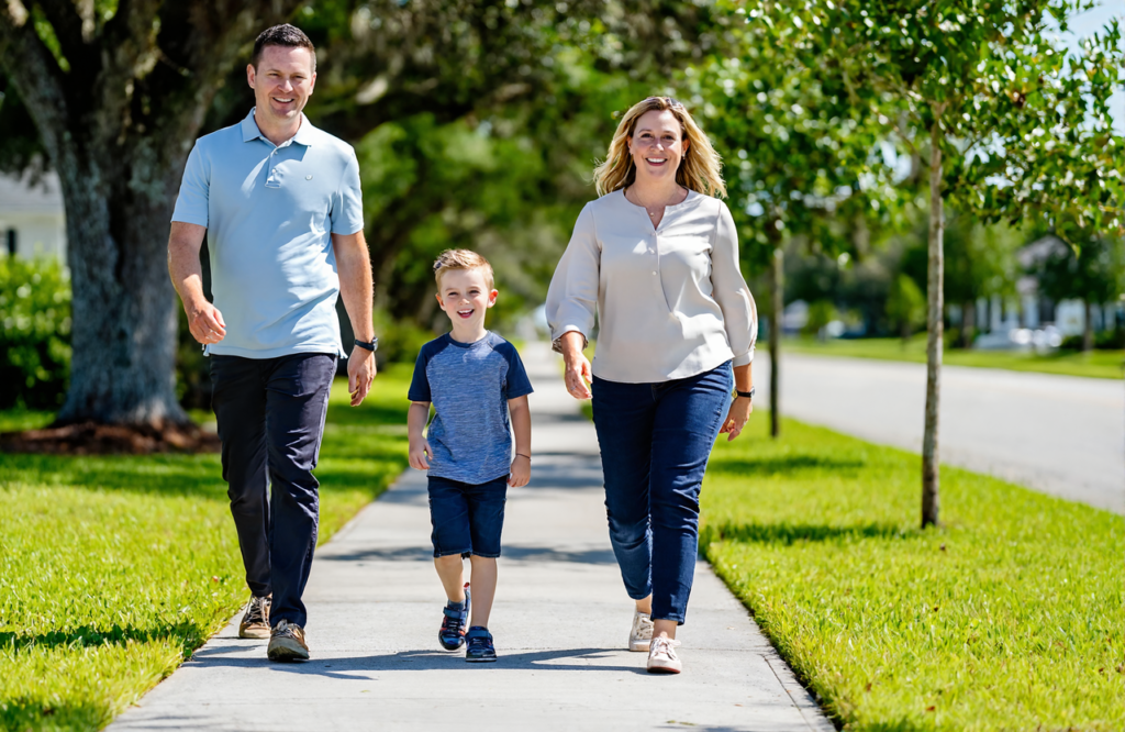 A family walking together on a sunny Gulf Coast neighborhood sidewalk