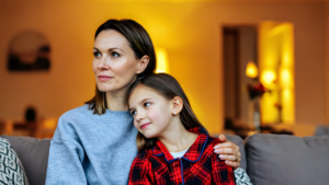 A mother comforting her daughter at home on an autumn evening, the moment parents start searching kids urgent care near me
